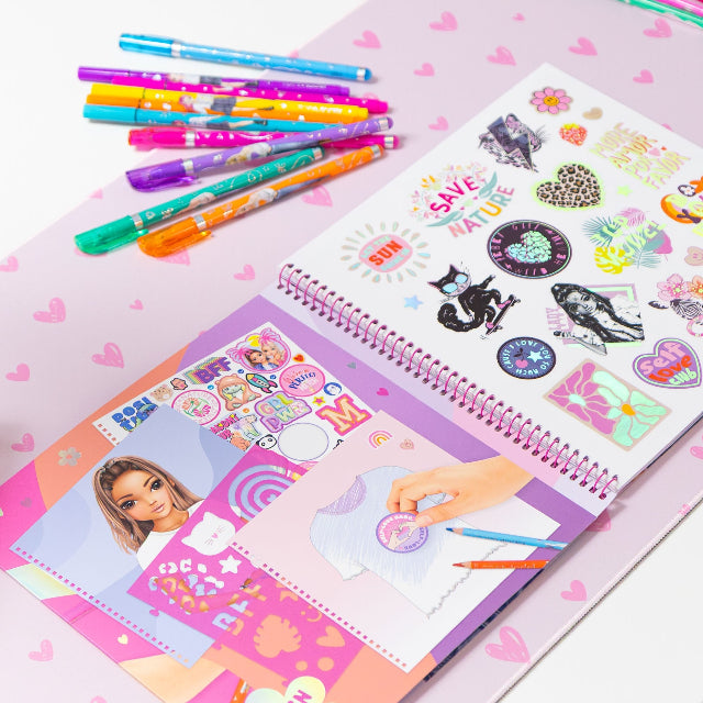 Colorful stationery items including pens and a notebook with stickers on a pink background.